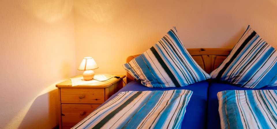 Schlafzimmer und Nachttisch der Ferienwohnung Gobert.